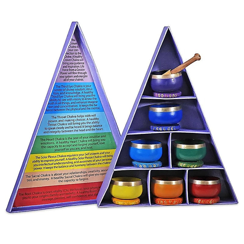 Set mit 7 dekorativen Klangschalen, jeweils in den Farben und mit den Symbolen der sieben Chakren, arrangiert in einer violetten Geschenkbox. Die Schalen sind aus Messing, Kupfer, Eisen, Zink und Bronze gefertigt und kommen mit einem Klangschalenschlägel und -Kissen.