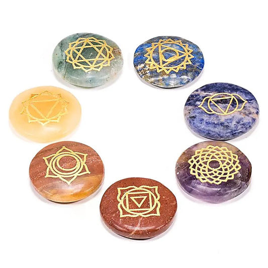 Handgefertigtes Chakra Edelstein-Set mit sieben flachen, runden Edelsteinen in verschiedenen Farben, verziert mit goldgravierten Chakrasymbolen. Das Set enthält Roter Jaspis, Pfirsich Aventurin, Goldquarz, grünen Aventurin, Sodalith, Amethyst und Lapislazuli. Ideal zur Unterstützung des Energieflusses, zur Balance der Chakren und für Meditation oder Dekoration. Jeder Edelstein weist natürliche Unterschiede in Farben und Formen auf.