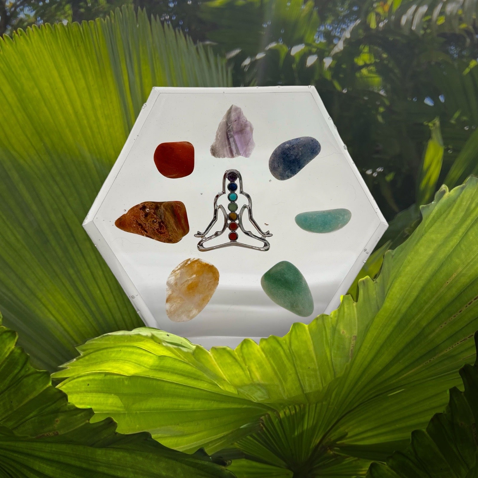 Handgefertigtes Hexagon aus Resin, gefüllt mit Trommelsteinen und Heilsteinen. Dieses einzigartige Dekorationsstück kann für Meditation bei Kerzenschein oder zur Verbesserung der Raumenergetik verwendet werden. Mit einem Lichtbalken/LED (separat erhältlich) verwandelt es sich in eine stilvolle Lampe und sorgt für eine faszinierende Beleuchtung.